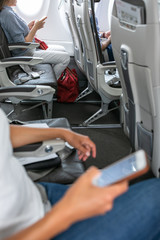 Passangers in abord a commercial flight using their cell phones during flight