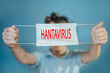 boy holds mask on outstretched arms on blue background. child with flu, influenza or cold protected from viruses, pollution in bad epidemic situation, among patients with coronavirus