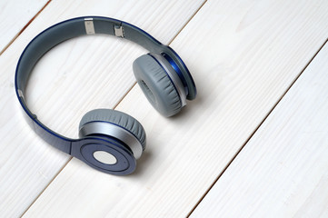 Blue and silver modern headphones on a white wooden background