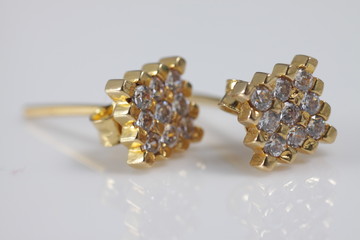 Macro shot of square gold ear ring on an isolated background