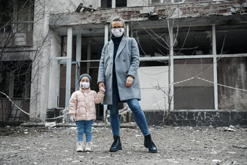 Woman and daughter wearing facial disposable mask to avoid viral infection. Coronavirus protection