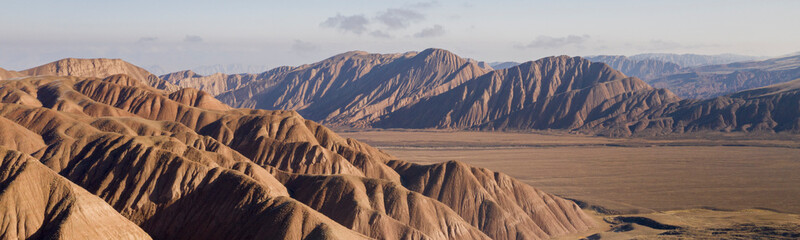 aerial landscape of the amazing Ozero Torpo, a lake surrounded by eroded mud hills along the...
