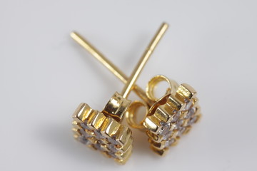 Macro shot of square gold ear ring on an isolated background