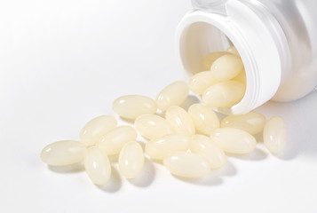 Vitamin D capsules on a white surface with copy space