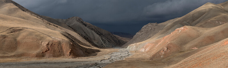 the first autumn snow over the colorful red rocks of the Arpa valley along the Arpa and Jamanti river in the Tian Shan mountains