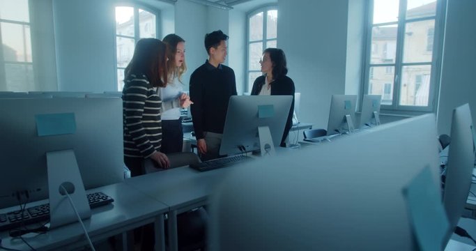 Happy communication. Young startup team in office, laughing discussing a project. Collective brainstorming. Multi ethnic team working together. Managers accept interns work