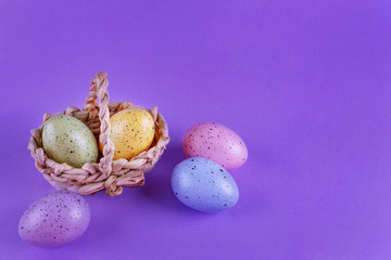 Easter eggs in a basket on a lilac background