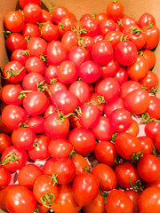 A lot of ripe cherry tomatoes on a market counter. Food tomato background.