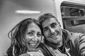 Happy couple seated on a subway train