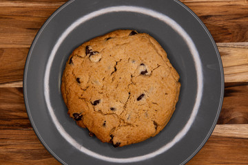 large baked delicious chocolate chip cookie on a grey plate