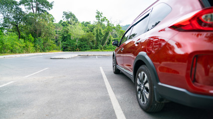 Fototapeta na wymiar Red suv car parked on concrete parking area Automotive Industry Used automobile business copy space.