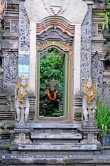 A stone entrance door decorated with stone statues of Balinese gods and demons