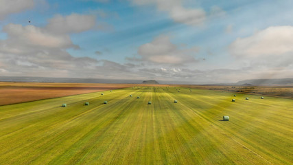 Naklejka premium Aerial view of iceland meadows with hay bales in summer season