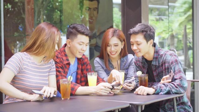 Asian young people using mobile phone in cafe