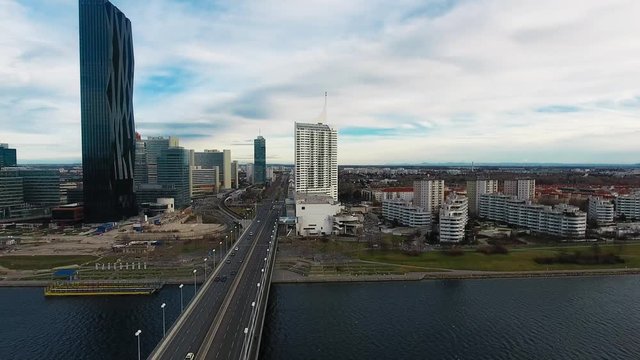 Aerial Panoramic View Of Cars Driving On Wien Reichsbrucke Bridge Across The Danube And Vienna Skyline In Austria 