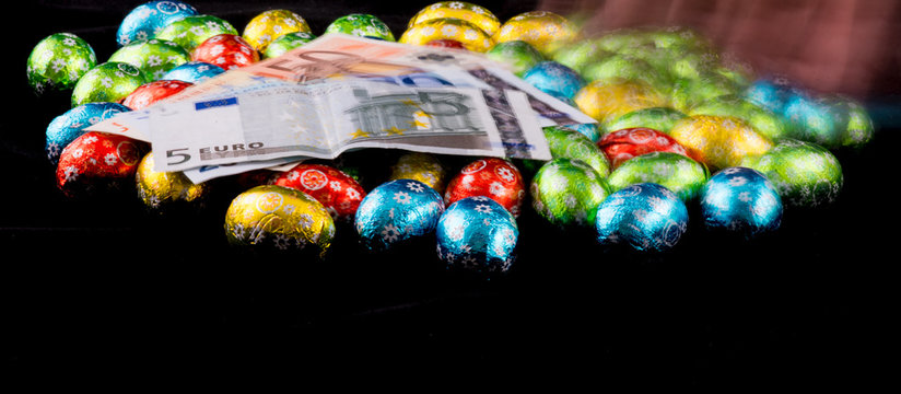 Hand moving Easter Egges with Euro Banknotes