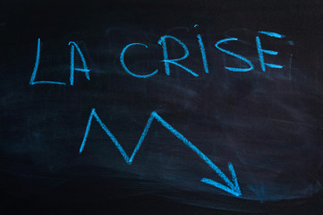 The word "crisis" in french. The inscription "crisis" on the blackboard. Blue chalk