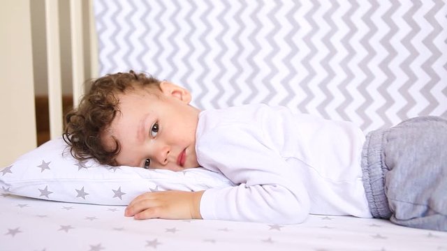 a bored sick child is lying in a crib. Self-isolation, quarantine precautions in connection with the epidemic of coronavirus