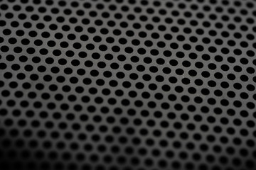 Black metal texture with round holes. Industrial background.