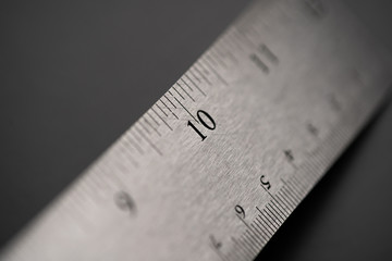 Metal ruler on a black leather isolated background with black numbers and scale. Show scale in black digit.