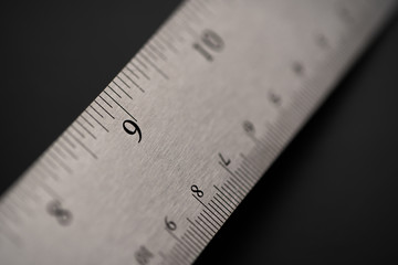 Metal ruler on a black leather isolated background with black numbers and scale. Show scale in black digit.