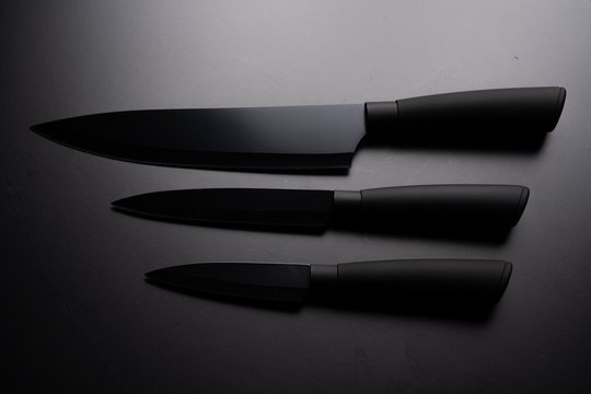 Black chef knife isolated on black background.