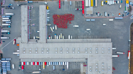 Aerial top down view of the large logistics park with warehouse, loading hub with semi trucks with cargo trailers standing at the ramps for load/unload goods © Golden eagle