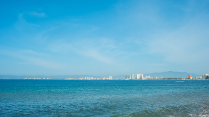 Bright Blue Ocean Beach With Buildings in the Background In Puerto Vallarta Mexico