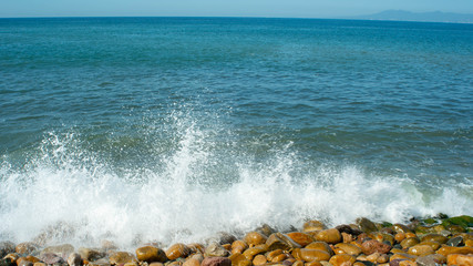 Bright Blue Ocean Crashing up Against Rocks