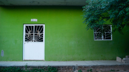 Bright Lime Green Building with Large White Door In Small Mexican Neighborhood