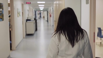young female doctor walks in an empty hospital ward, slow motion - Powered by Adobe