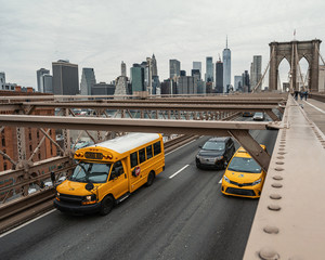 Taxi und Schulbus auf Brooklyn Bridge