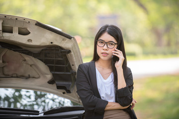 Asia young woman is standing near her broken car.