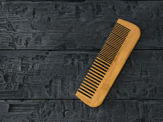 Wooden comb comb on a wooden background. - obrazy, fototapety, plakaty