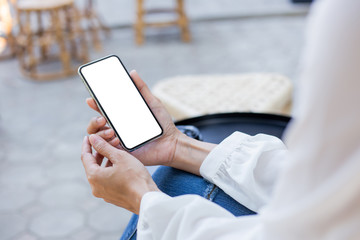 Mockup image blank white screen cell phone.woman hand holding texting using mobile on desk at coffee shop.background empty space for advertise text.people contact marketing business,technology