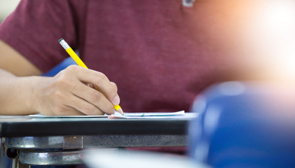 high school,university student study.hands holding pencil writing paper answer sheet.sitting lecture chair taking final exam attending in examination classroom.concept scholarship for education abroad