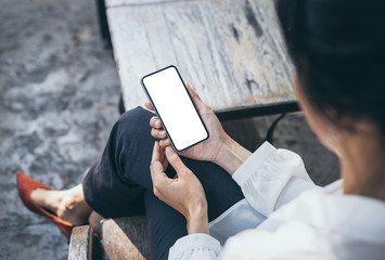 Mockup image blank white screen cell phone.woman hand holding texting using mobile on desk at coffee shop.background empty space for advertise text.people contact marketing business,technology