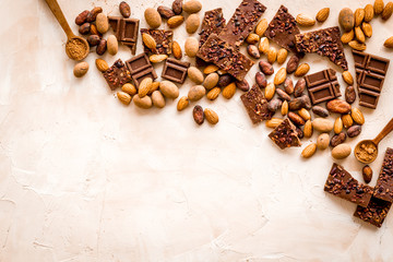 Chocolate frame. Broken slices and nuts on light background top-down copy space