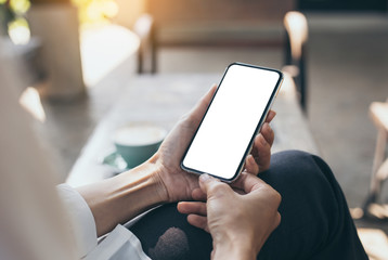 Mockup image blank white screen cell phone.woman hand holding texting using mobile on desk at coffee shop.background empty space for advertise text.people contact marketing business,technology