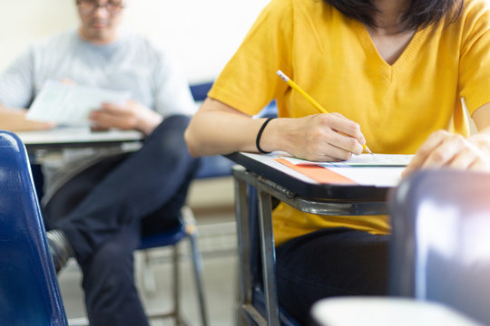 high school,university student study.hands holding pencil writing paper answer sheet.sitting lecture chair taking final exam attending in examination classroom.concept scholarship for education abroad