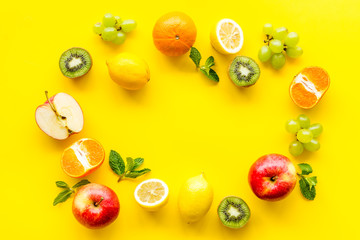 Colorful fruit mockup. Cut apple, kiwi, citrus on yellow background top-down copy space