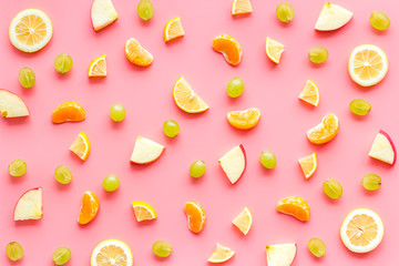 Colorful summer fruits background on pink table top view