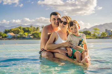 Luxury resort swimming pool. Happy family tourists relaxing in holiday retreat on summer travel vacation enjoying ocean background