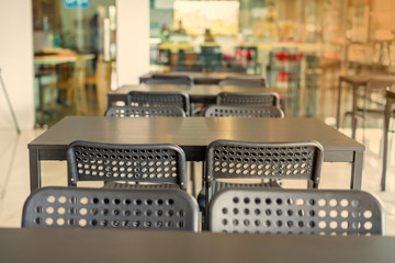 Black chairs that have in common Pattern Arranged in a form in front of the coffee shop with orange light