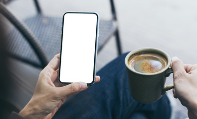 Mockup image blank white screen cell phone.woman hand holding texting using mobile on desk at coffee shop.background empty space for advertise text.people contact marketing business,technology