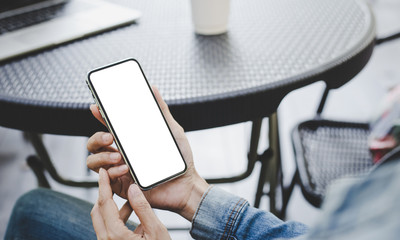 Mockup image blank white screen cell phone.woman hand holding texting using mobile on desk at coffee shop.background empty space for advertise text.people contact marketing business,technology