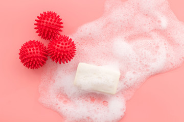 Coronavirus prevention. Soap and foam near virus model on pink background top-down