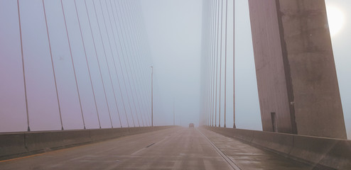 driving across the bridge on a foggy morning