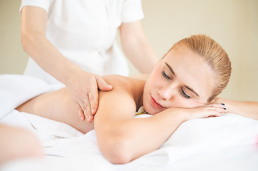 Fototapeta na wymiar Health care and thai massage. Beautiful woman getting back and shoulder massage in spa salon