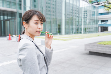 電子タバコを吸う若いビジネスウーマン